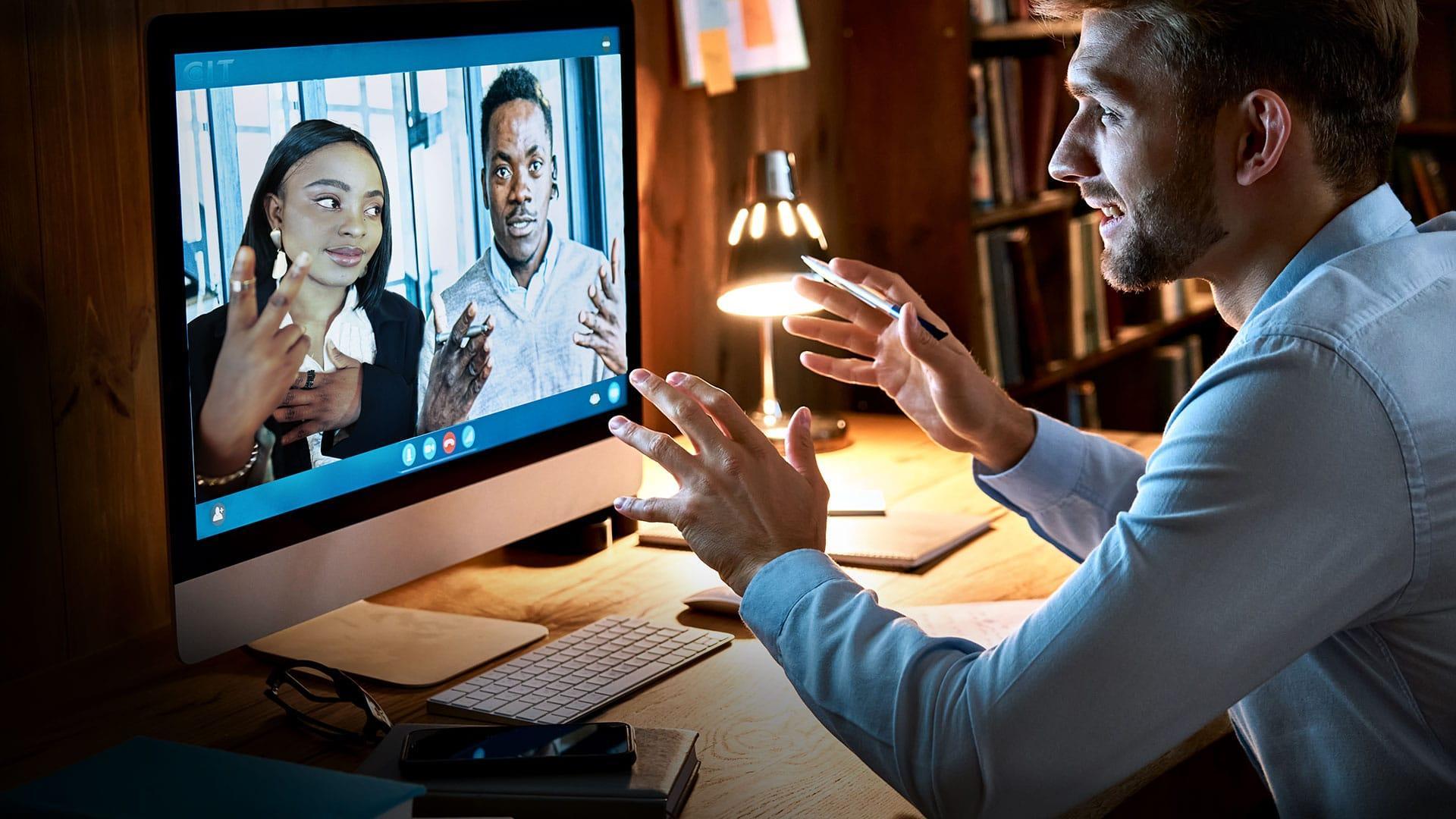 Man talking to people over webcam on his computer.